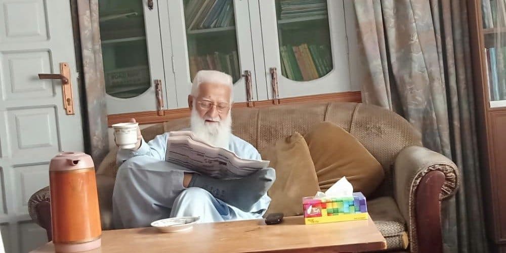 Reading a newspaper at home.