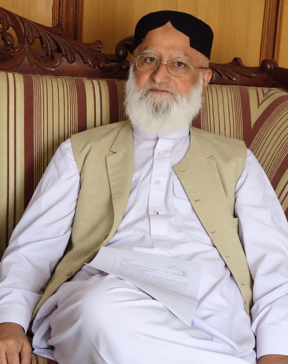 Seated, holding a document.